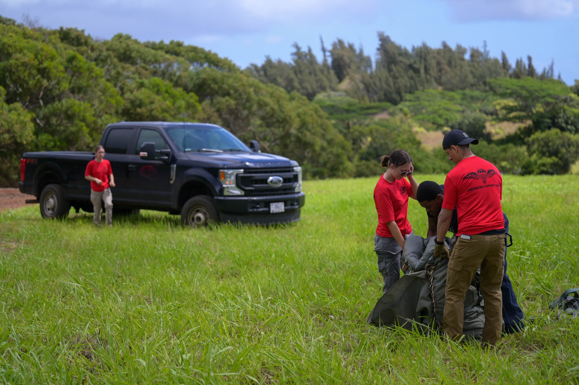 U.S. Air Force Airmen pack a used parachute after receiving an airdrop from a C-17.