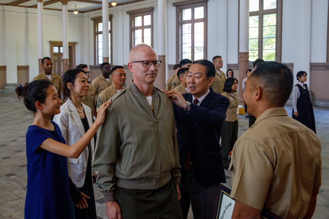 U.S. Marine Corps Master Gunnery Sgt. Scott McAdam, the communication strategy and operations staff non-commissioned officer in charge of MCAS Iwakuni, and Iowa native, is pinned by his family during a promotion ceremony at JMSDF Etajima, Japan, May. 4, 2025. Master Gunnery Sgt. Scott McAdam, the communication strategy and operations staff non-commissioned officer in charge of Marine Corps Air Station Iwakuni, was promoted to the rank of master gunnery sergeant, one of the highest levels of enlisted leadership in the Marine Corps, where he will serve as the technical expert in his military occupational specialty. JMSDF Etajima is the former home of the Japanese Naval Academy and current home to the JMSDF Officer Candidate School and 1st Maritime Service School. (U.S. Marine Corps photo by Lance Cpl. David Getz)