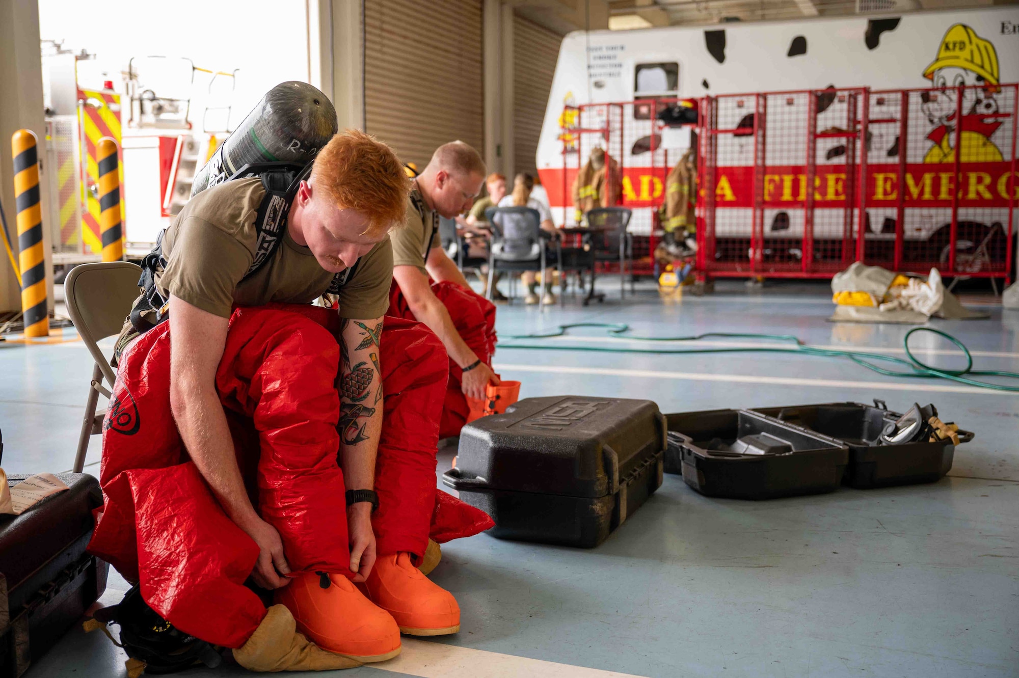service members put on protective suits