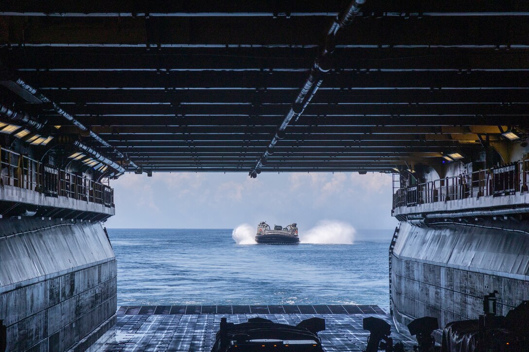 A U.S. Navy Landing Craft Air Cushion approaches the U.S. Navy Wasp-class amphibious assault ship USS Iwo Jima (LHD 7), during LCAC operations in support of Composite Training Unit Exercise while underway in the Atlantic Ocean, June 22, 2025. During COMPTUEX, the IWO ARG and 22nd MEU(SOC), refine tactics, techniques, and procedures to execute warfighting functions that enhance operational readiness and lethality as a unified IWOARG/22 MEU(SOC) team. (U.S. Marine Corps photo by Cpl. Sharon Errisuriz)