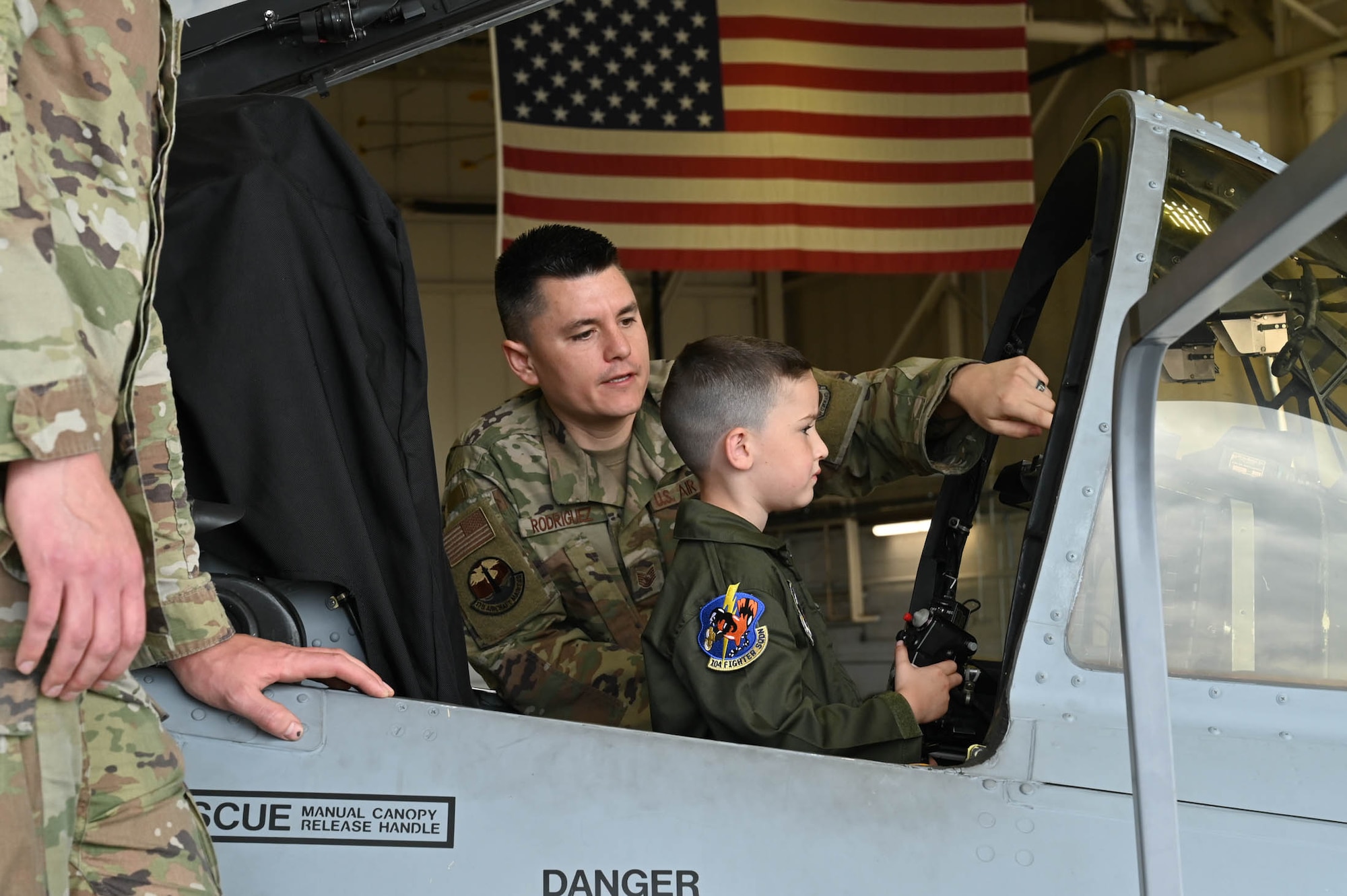 Maryland Air National Guard Tech. Sgt. Daniel Roriguez (left), a crew chief assigned to the 175th Maintenance Squadron, shows Maverick Bell (right) an A-10C Thunderbolt II static display at Warfield Air National Guard Base at Martin State Airport, Maryland, June 7, 2025. Bell and his family attended "Pilot For a Day," facilitated by the Gold in Fight Foundation, which invites children and families from the local community who have catastrophic illnesses to spend the day with pilots. (U.S. Air National Guard Photo by Staff Sgt. Laura Virtue)
