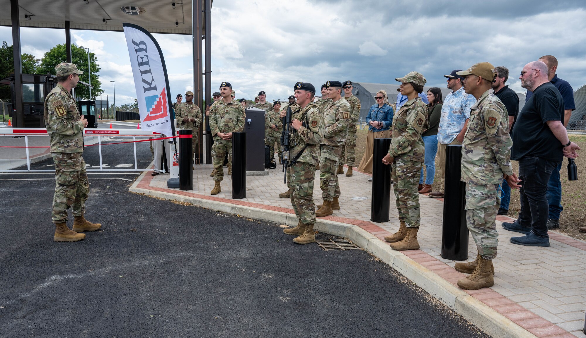 U.S. Air Force Col. Ryan Garlow, left, 100th Air Refueling Wing commander, addresses the crowd during a new gate reveal at RAF Mildenhall, England, June 24, 2025.