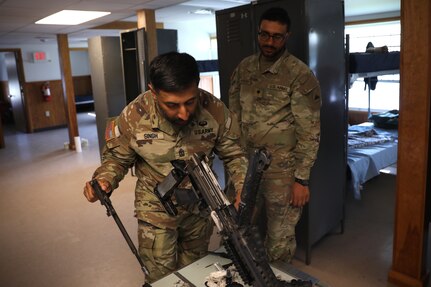 U.S. Army 1st Sgt. Sahib Singh and Spc. Islam Mahmoud, financial management technicians with the 1946th Finance Company, examine a weapons system on Fort Indiantown Gap, Pa., June 11, 2025. The 1946th did extensive firearm and maintenance and marksmanship training as part of their annual training. (U.S. Army Photo by Spc. Carrol Hughes)