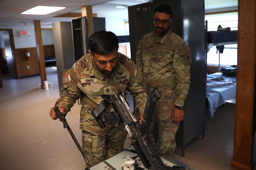 U.S. Army 1st Sgt. Sahib Singh and Spc. Islam Mahmoud, financial management technicians with the 1946th Finance Company, examine a weapons system on Fort Indiantown Gap, Pa., June 11, 2025. The 1946th did extensive firearm and maintenance and marksmanship training as part of their annual training. (U.S. Army Photo by Spc. Carrol Hughes)