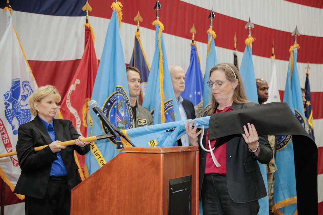 People stand at attention as new flags are displayed