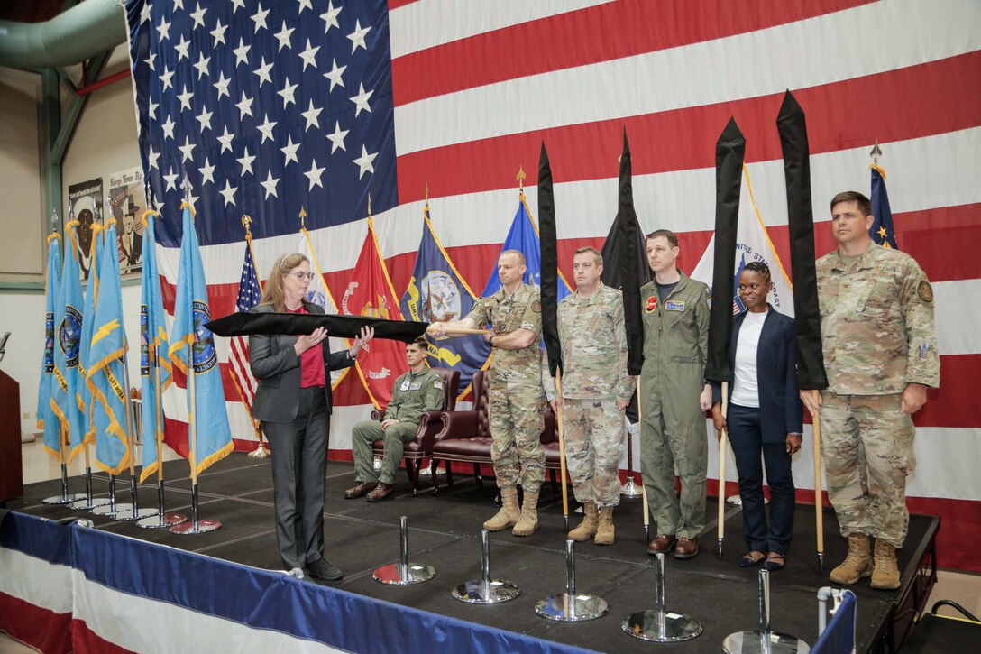 People stand at attention as a new flag is revealed