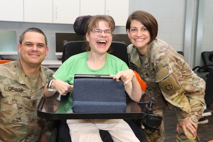 Sgt. 1st Class Justin Craggs, left, and Master Sgt. Christine Andrizzi, right, pause for a photo with an event participant during the Northwest Special Recreation Association’s Pursuit program, June 17, 2025.