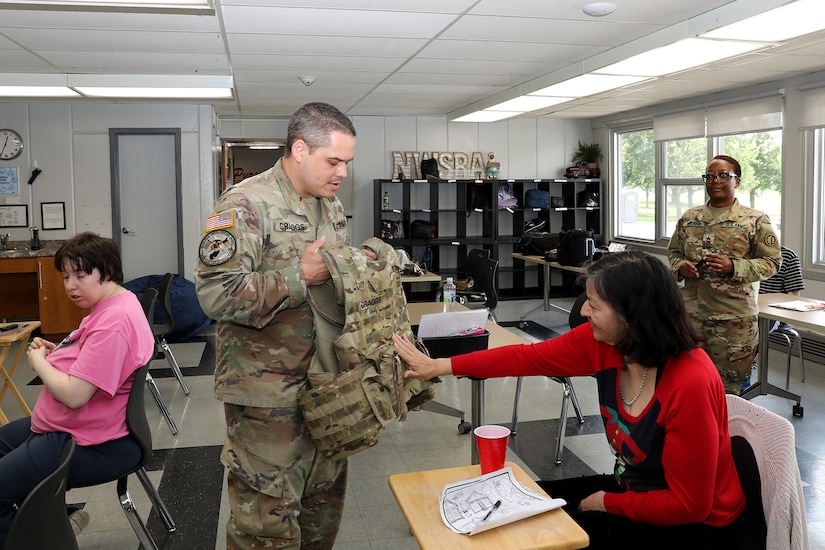 Sgt. 1st Class Justin Craggs displays one of his personal protective equipment pieces to a Northwest Special Recreation Association attendee during the NWSRA’s Pursuit program, June 17, 2025.