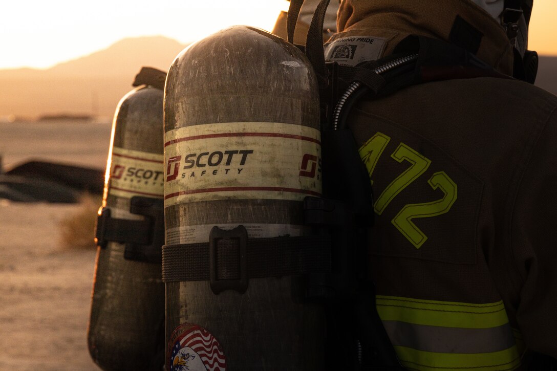 U.S. Marines with Aircraft Rescue and Fire Fighting, Marine Wing Support Squadron 472, 4th Marine Aircraft Wing, puts on firefighting gear during a simulated aircraft fire-fighting drill at Integrated Training Exercise 3-25, Marine Corps Air Ground Combat Center, Twentynine Palms, California, June 17, 2025. ITX is a critical Marine Air-Ground Task Force exercise for the Marine Forces Reserve’s training cycle, confirming unit readiness through live-fire and combined-arm integration. (U.S. Marine Corps photo by Lance Cpl. Edward Spears)