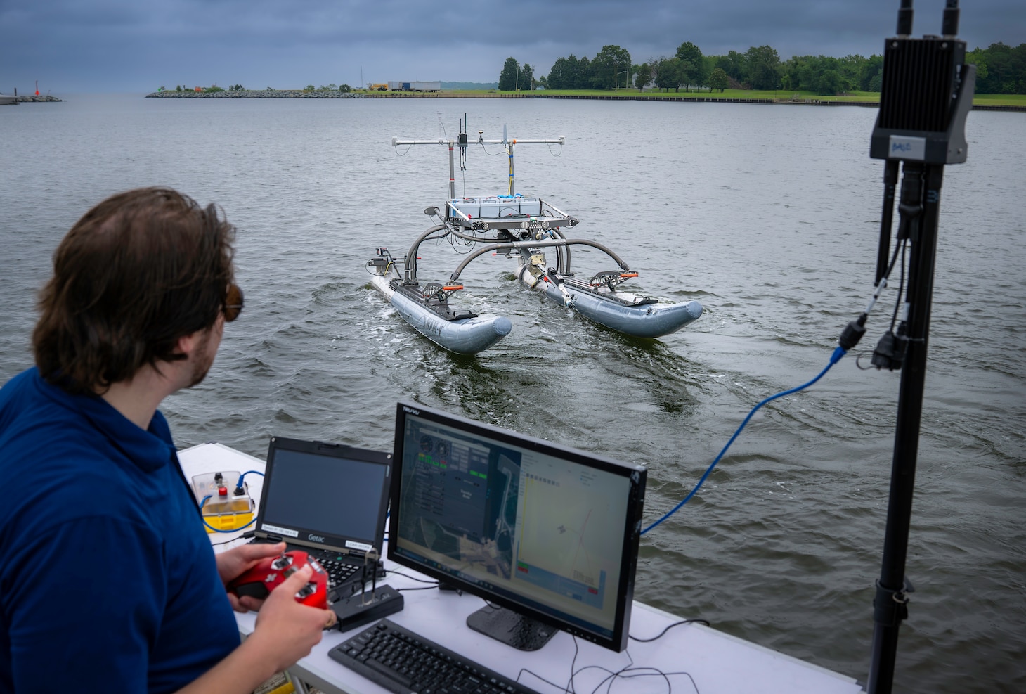Raymond Koehler, a mechanical engineer at the Naval Air Warfare Center Aircraft Division, demonstrates unmanned swarm mission planning software at Naval Air Station Patuxent River’s West Basin Marina in Md. on June 17, 2025. The software helps the Navy plan missions with unmanned systems by simulating drone, sensor, and arrangement combinations to achieve mission goals at sea ultimately providing warfighters faster and more effective decision making. (U.S. Navy photo by Todd Frantom)