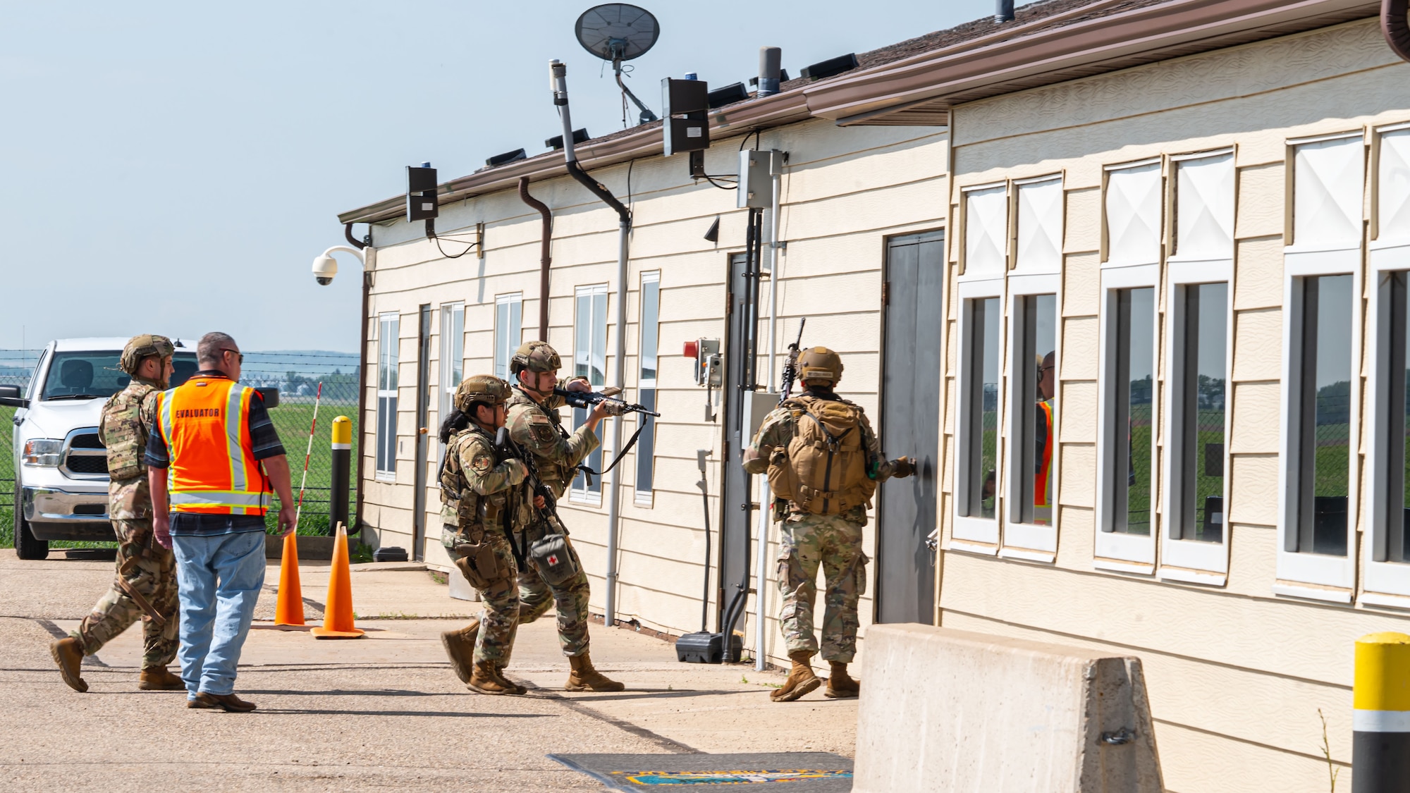 Airmen from the 91st Security Forces Group prepare to enter a building during a mass casualty exercise at a missile alert facility outside of Minot Air Force Base, North Dakota, June 17, 2025. This partnership allows local law enforcement to gain firsthand experience with military procedures during active shooter scenarios.