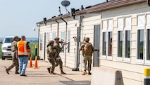 Airmen from the 91st Security Forces Group prepare to enter a building during a mass casualty exercise at a missile alert facility outside of Minot Air Force Base, North Dakota, June 17, 2025. This partnership allows local law enforcement to gain firsthand experience with military procedures during active shooter scenarios.