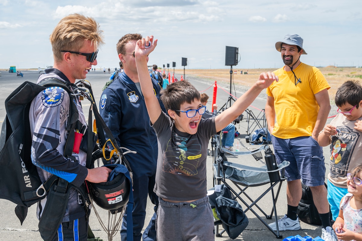 U.S. Air Force First-Class Cadet Carter Beswick, left, and Second-Class Cadet Connor Bartz, both 98th Flying Training Squadron Wings of Blue demonstrators, engage with audience members during the 2025 Moses Lake Airshow at Grant County International Airport, Washington, June 20, 2025.