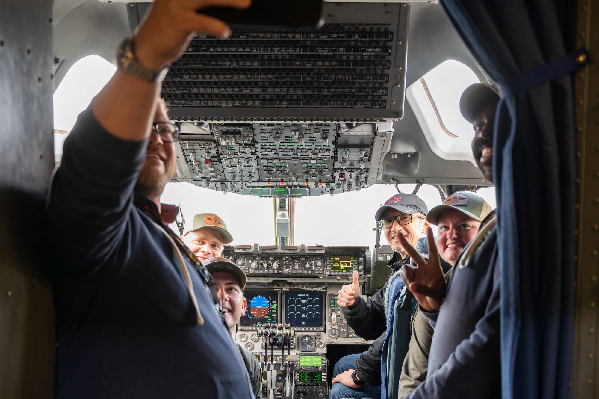 U.S. Air Force Maj. Ross Wiginton, back left, Capt. Nathan Foss, center left, and Capt. Jennifer Lucas, center right, all C-17 West Coast Demonstration Team and 8th Airlift Squadron pilots, engage with 2025 Moses Lake Airshow participants at Grant County International Airport, Washington, June 21, 2025.