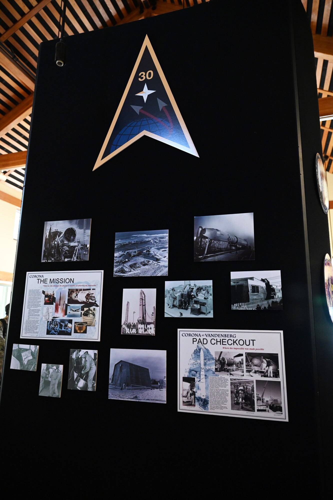 a wall displays a delta badge and photos of missiles and rockets