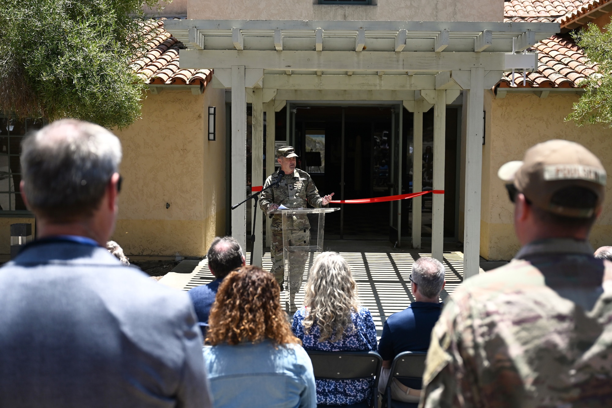 a man speaks at a podium to a crowd of people