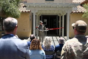 a man speaks at a podium to a crowd of people