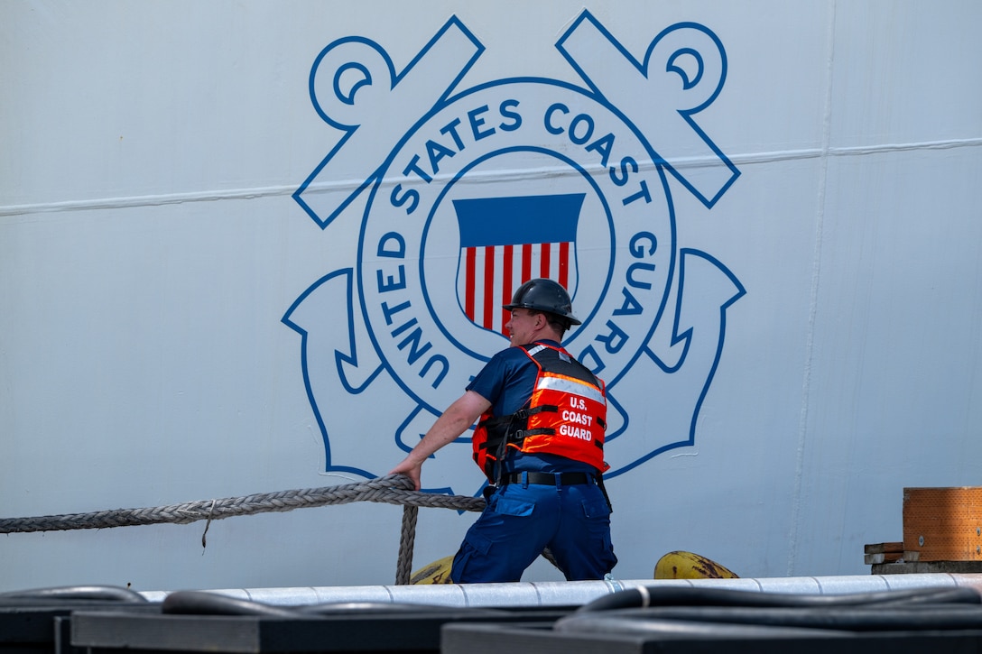 A U.S. Coast Guard Base Seattle crewmember conducts mooring operations for the departure of U.S. Coast Guard Cutter Healy (WAGB 20) from Base Seattle, June 19, 2025. The Healy will conduct high latitude science and research missions in the Arctic. (U.S. Coast Guard photo by Petty Officer 2nd Class Briana Carter)