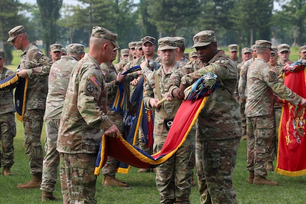U.S. Army Soldiers assigned to 1 SBCT 2nd Infantry Division/ROK-U.S. Combined Division, furl their unit guidons during a Transfer of Authority ceremony, on Camp Casey, South Korea, June. 18, 2025.