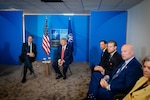 The NATO secretary general and U.S. president sit in chairs for a briefing.