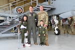 Maryland Air National Guard Capt. Carson Miller (middle-left), an A-10C Thunderbolt ll pilot assigned to the 104th Fighter Squadron, Master Sgt. Jonathan Lorenz (middle-right), avionics technician for the 175th Maintenance Squadron, and Elena LeMoine (left) and Maverick Bell (right), pose for a group photo in front of an A-10C Thunderbolt II static display at Warfield Air National Guard Base at Martin State Airport, Maryland, June 7, 2025. LeMoine and Bell, as well as their families, attended 