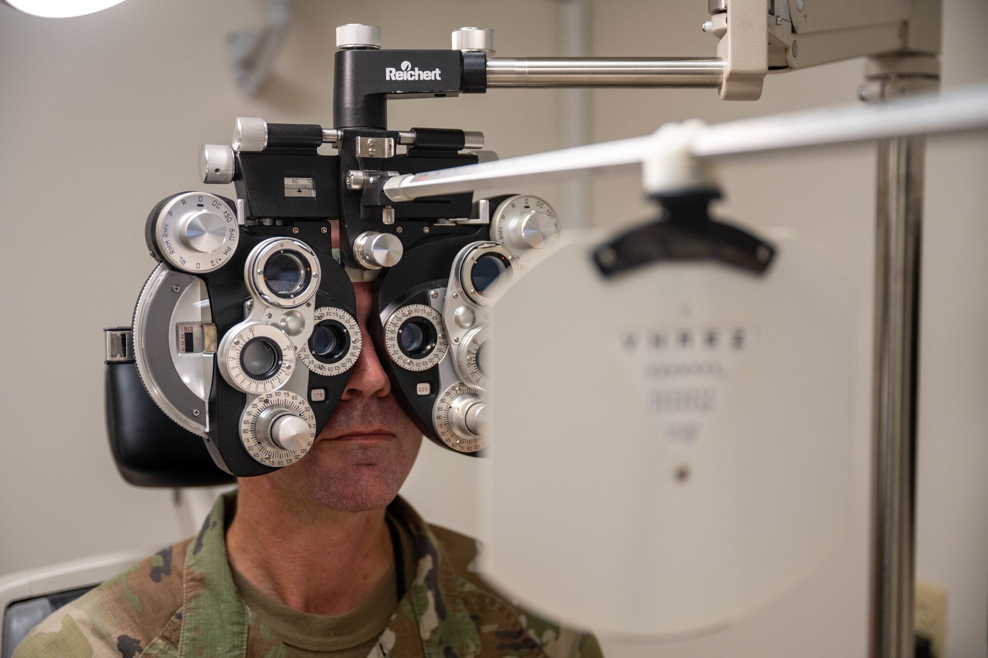 A patient in the optometry office on Joint Base Pearl Harbor-Hickam, Hawaii, looks through a phoropter.