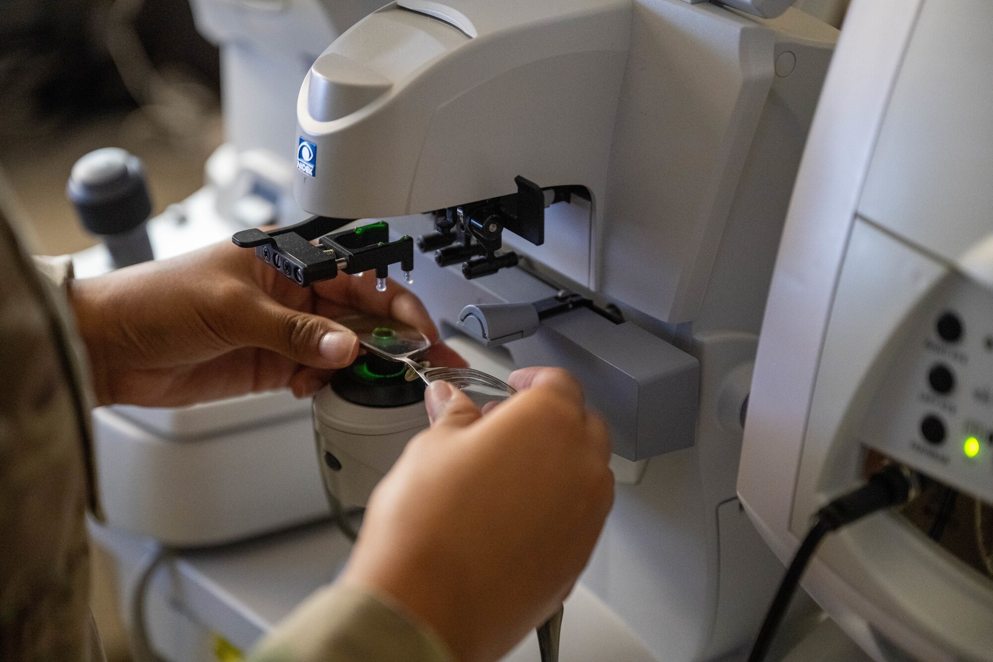A U.S. Air Force Airmen examines a pair of glasses with a machine in an optometry office on Joint Base Pearl Harbor-Hickam, Hawaii.