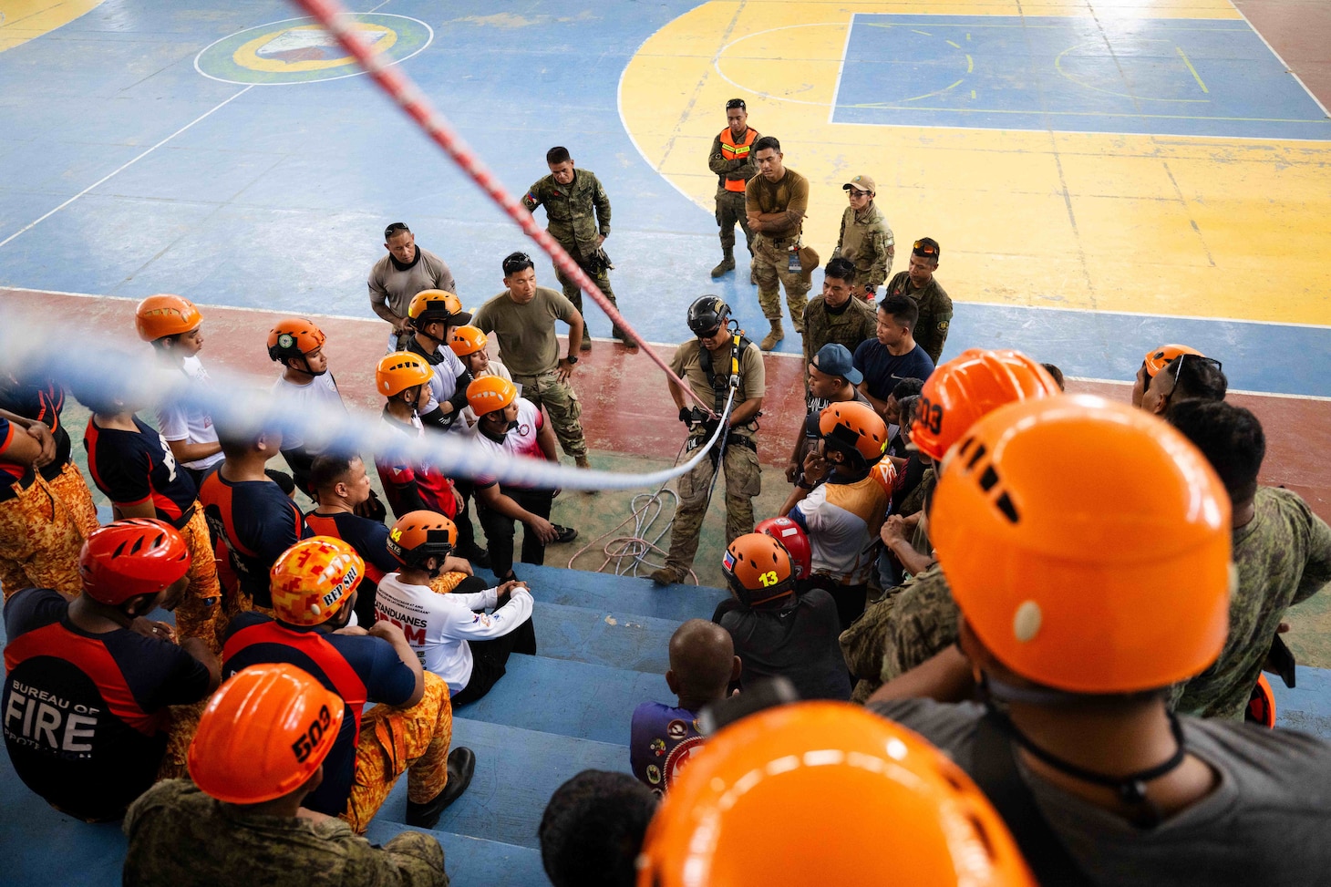 Virac, Philippines (June 3, 2025) – Hawaii National Guard 1st Sgt. Rodolfo Acosta, center, instructs local emergency responders and civilian authorities on the proper use of rappelling gear during a training session in Virac, Philippines, June 3, 2025. This effort is part of a two-week urban rescue training exercise supporting the humanitarian assistance and disaster response objectives of Pacific Partnership 2025. Now in its 21st iteration, Pacific Partnership series is the largest annual multinational humanitarian assistance and disaster management preparedness mission conducted in the Indo-Pacific. Pacific Partnership works collaboratively with host and partner nations to enhance regional interoperability and disaster response capabilities, increase security and stability in the region, and foster new and enduring friendships in the Indo-Pacific. (U.S. Navy photo by Mass Communication Specialist 2nd Class Jordan Jennings)