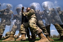 Sgt. 1st Class Andres Agag, a mortar team leader with Troop A, 1st Squadron, 18th Cavalry Regiment, California Army National Guard, pushes against the shields of other unit members while playing the role of an aggressive demonstrator during training at Joint Forces Training Base, California, on riot and crowd control techniques, June 22, 2025.