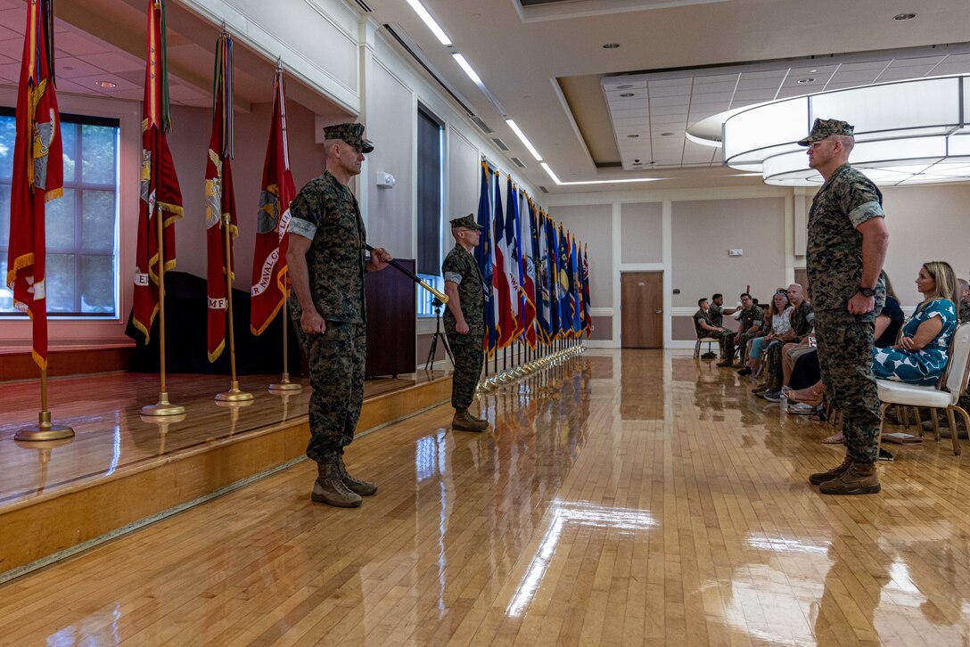 U.S. Marine Corps Sgt. Maj. Joshua K. Miller, left, outgoing sergeant major of II Marine Information Group, II Marine Expeditionary Force, Sgt. Maj. Shelby S. Smith, middle, oncoming sergeant major, and Col. Ian Fletcher, commanding officer, stand at attention, at Marine Corps Base Camp Lejeune, North Carolina, June 25, 2025. A relief and appointment ceremony is a military tradition that signifies all responsibilities and authorities being transferred between the old and new senior enlisted leader of the command. (U.S. Marine Corps photo by Lance Cpl. Daniel R. Garcia)