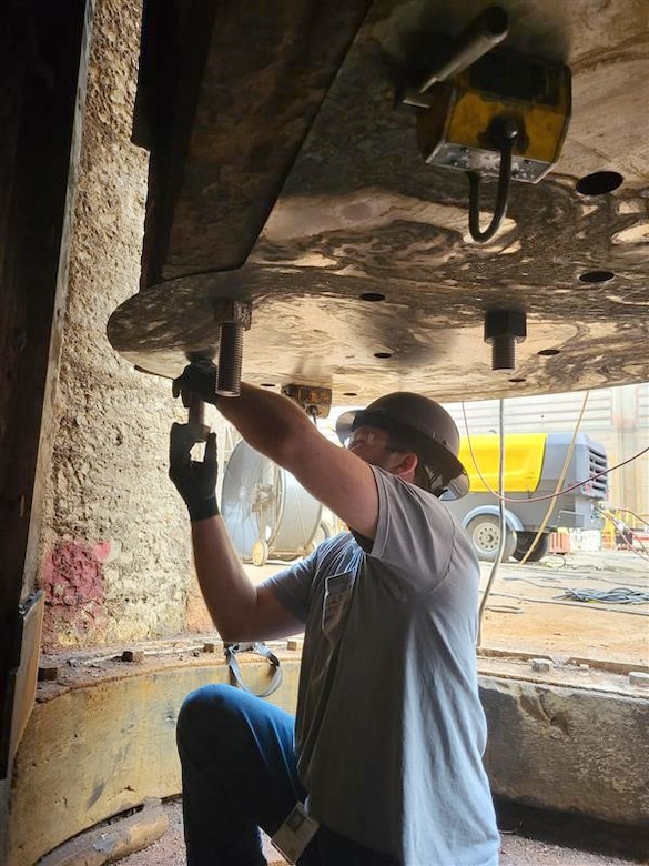 A member of the Regional Rivers Repair Fleet with the Huntington District prepares a bearing plate template at Wilson Lock May 15, 2025, used by the repair team to ensure bolt holes would align during installation of new miter gate components. (USACE Photo by Justin Reed)