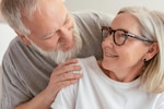 Older man and woman smile at each other