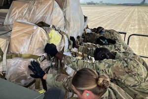 Airmen assigned to the 49th Aerial Port Squadron push palletized humanitarian aid onto a C-17 Globemaster III at Grissom Air Reserve Base, Ind., Jun. 6, 2025. Coordinated by the Denton Humanitarian Assistance program, the cargo included donated items such as food, wheelchairs and toiletries to give support to elderly and disabled people in Guatemala. (Courtesy photo.)