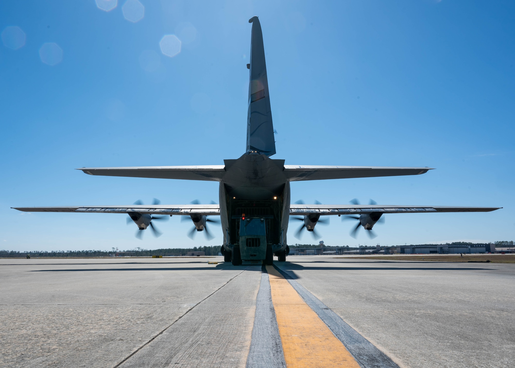 Personnel load a pallet full of gear onto a C-130 Hercules.