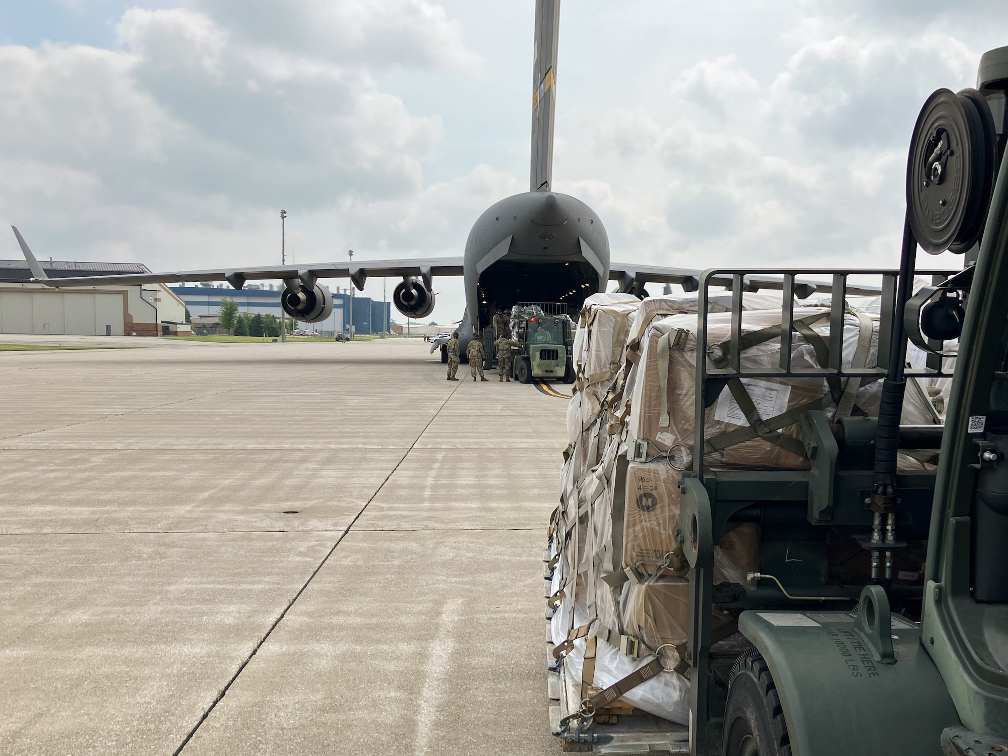 Airmen assigned to the 49th Aerial Port Squadron prepare to load humanitarian cargo onto a C-17 Globemaster III during an engine running onload/offload operation at Grissom Air Reserve Base, Ind., Jun. 6, 2025. ERO operations are often used in deployed environments to reduce aircraft ground time. (Courtesy photo.)