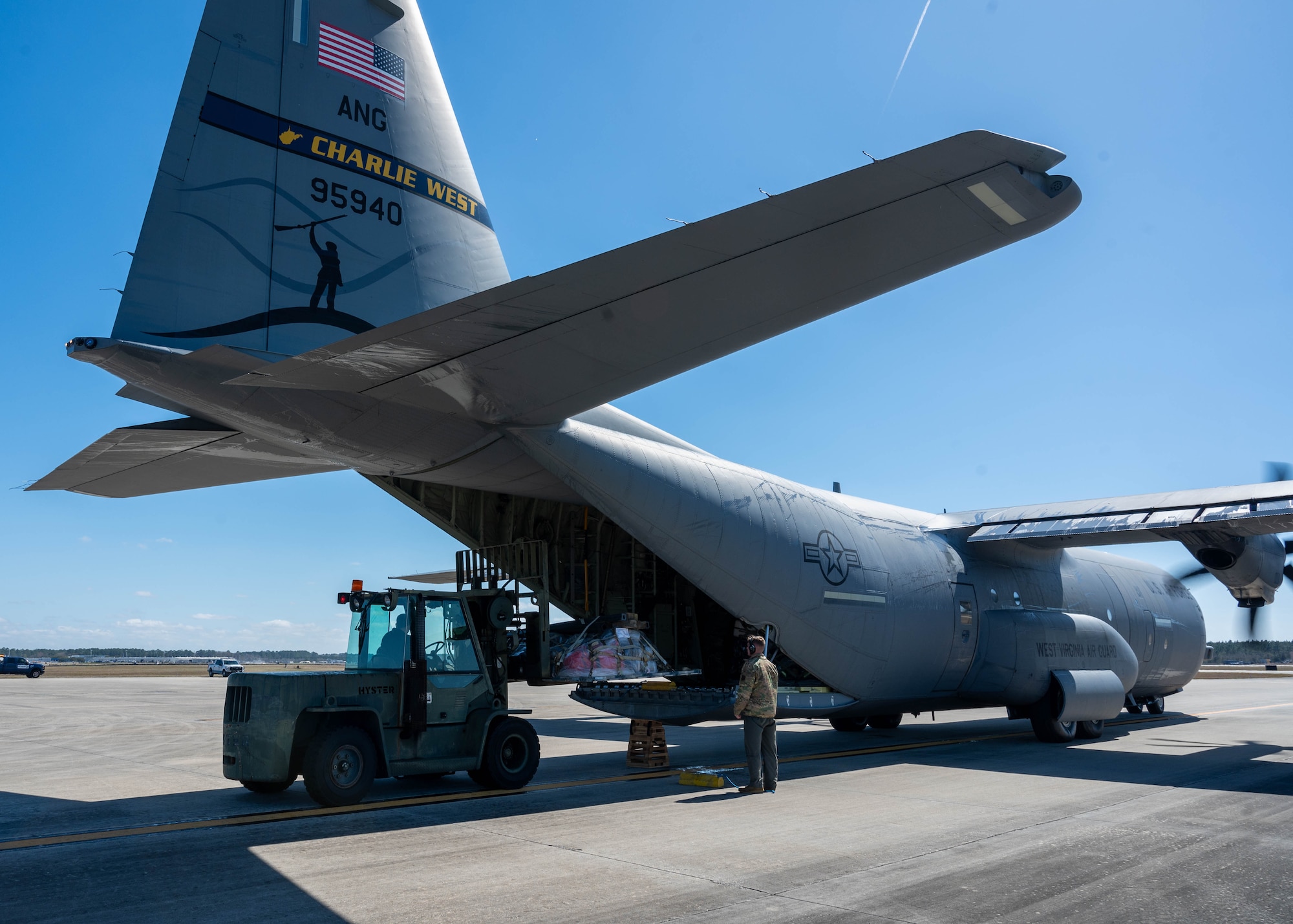 Personnel load a pallet full of gear onto a C-130 Hercules.