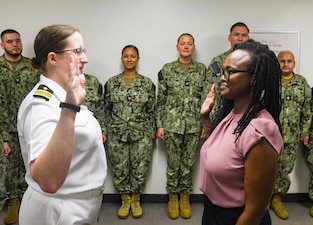 060625-N-FB730-1001 CAMP LEJEUNE (June 6, 2025) Dr. Andrea Karsten (right) commissions as a Navy psychiatric officer in the out-patient mental health conference room of naval Medical Center Camp Lejeune on June 6, 2025. The Combined Military-Civilian Psychiatry Residency Program is a partnership between NMCCL and NOVANT Health that puts medical residents through four years of clinical training in psychiatry.