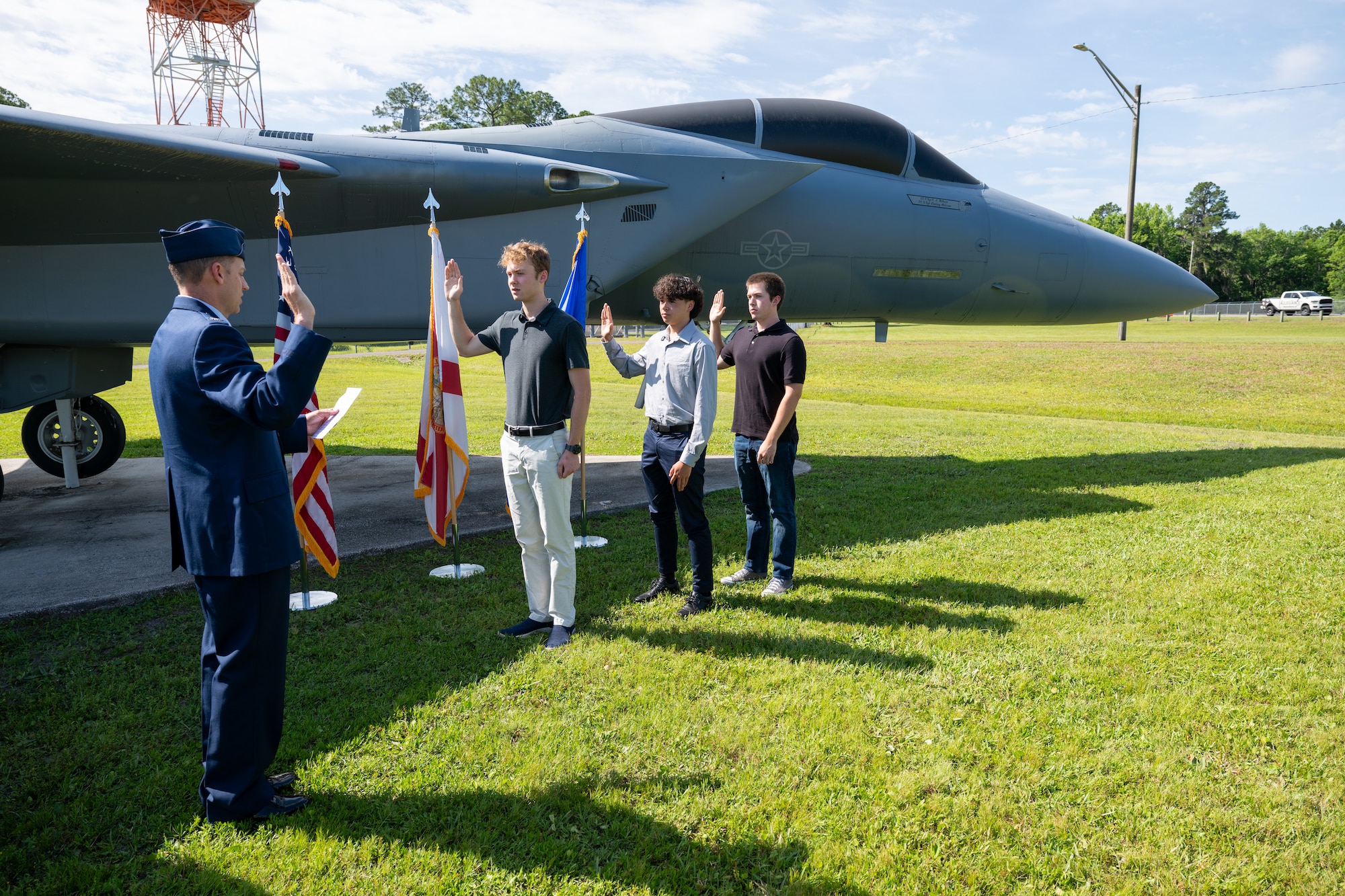 Photo of commander administering oath of enlistment to new recruits.
