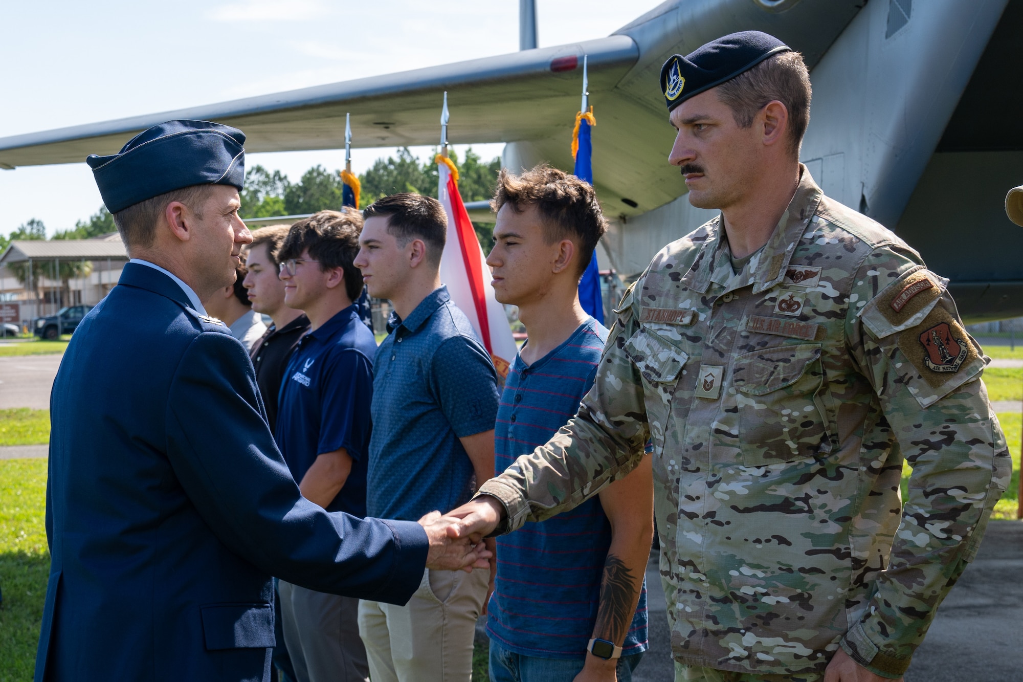 Photo of commander 'coining' Airman during a ceremony.