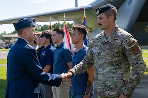 Photo of commander 'coining' Airman during a ceremony.