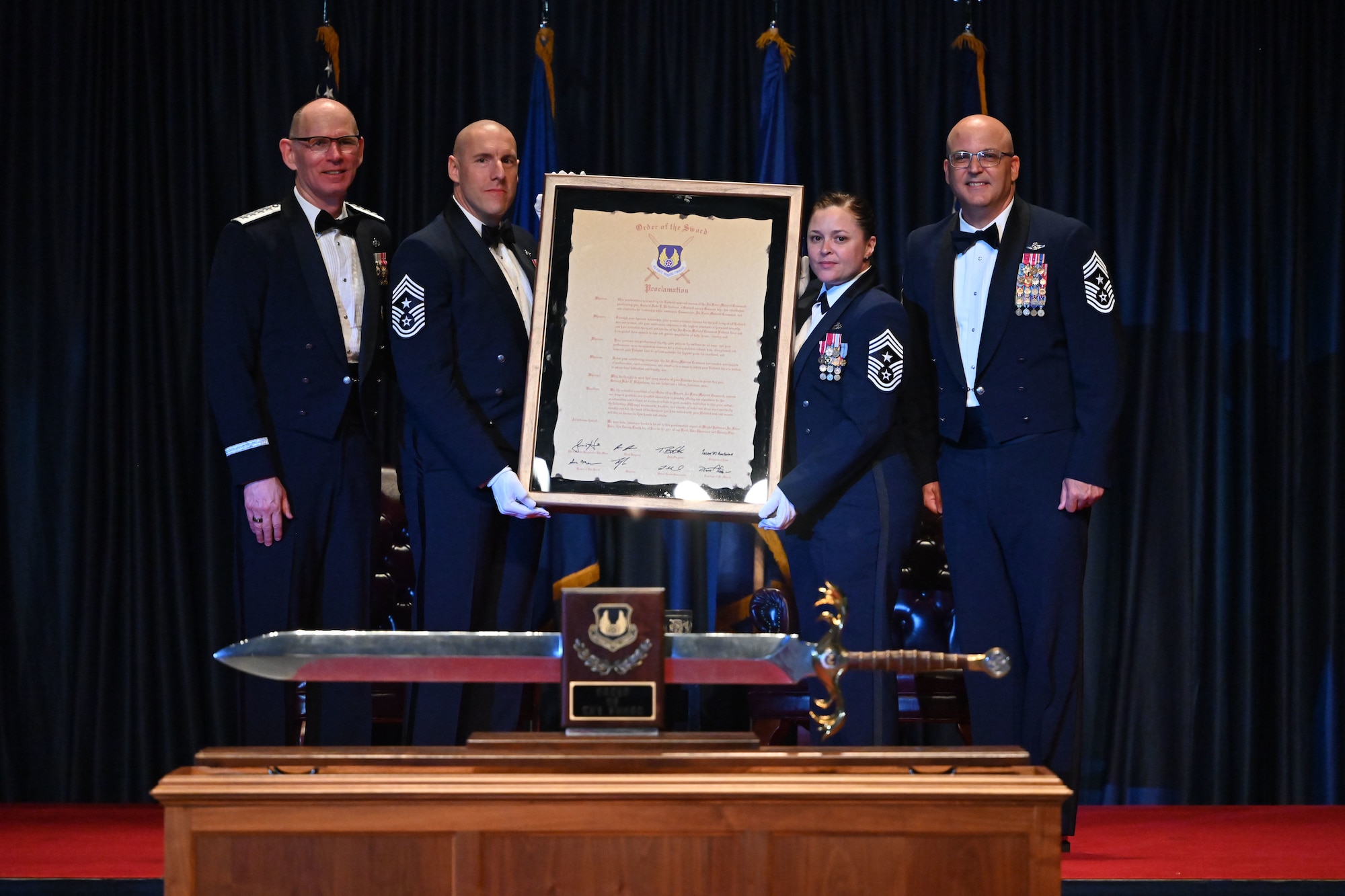 Gen. Duke Z. Richardson, commander, Air Force Materiel Command, poses with Chief Master Sgt. Jalil Samavarchian, Chief Master Sgt. Tessa M. Fontaine, and Chief Master Sgt. Bill Fitch following the presentation of the Order of the Sword proclamation.