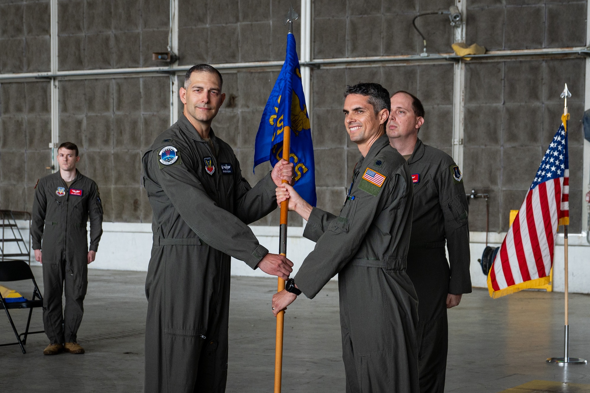 Two men hold a guidon between them.