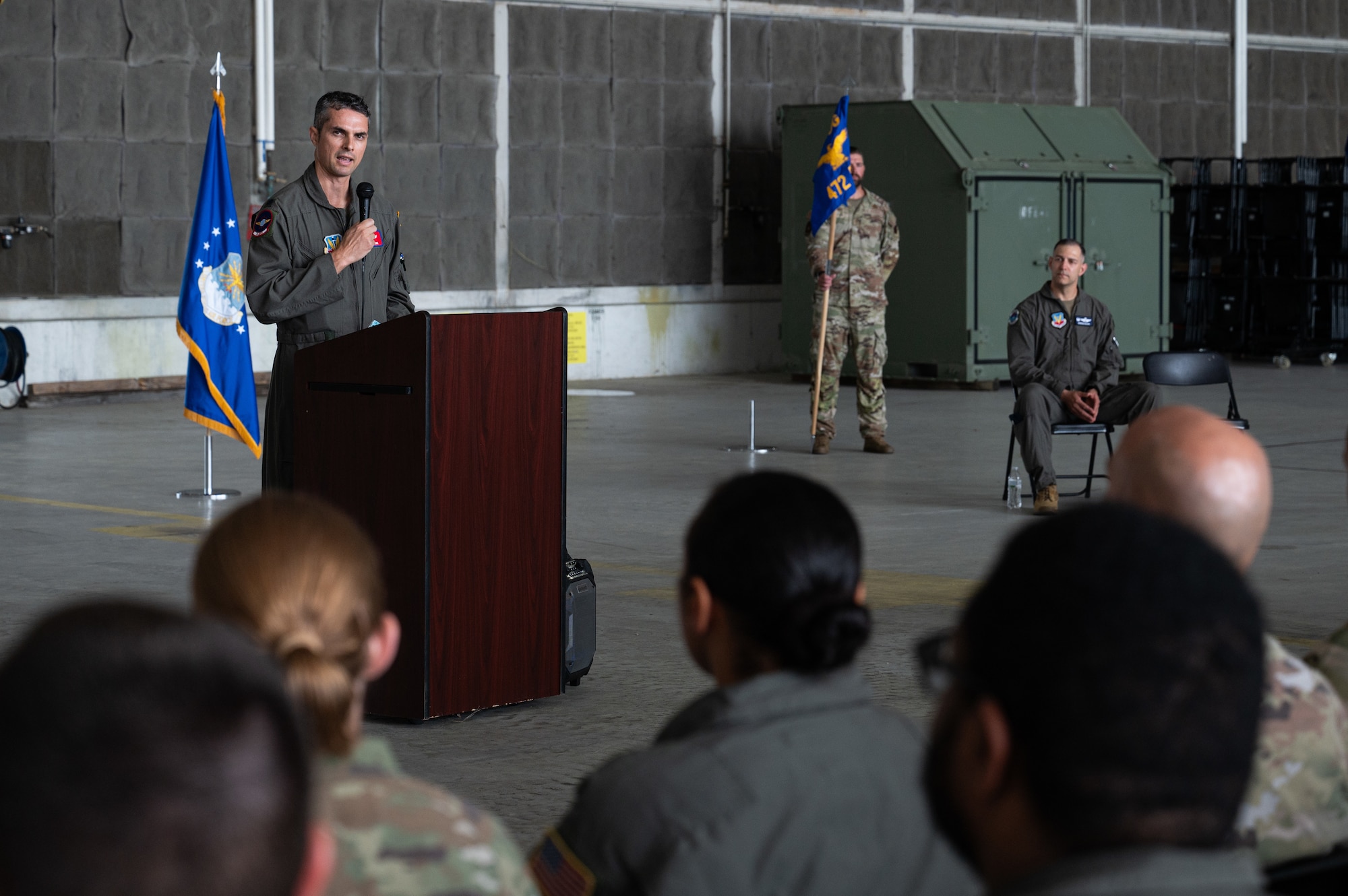 A man stands in front of a crowd and gives a speech.