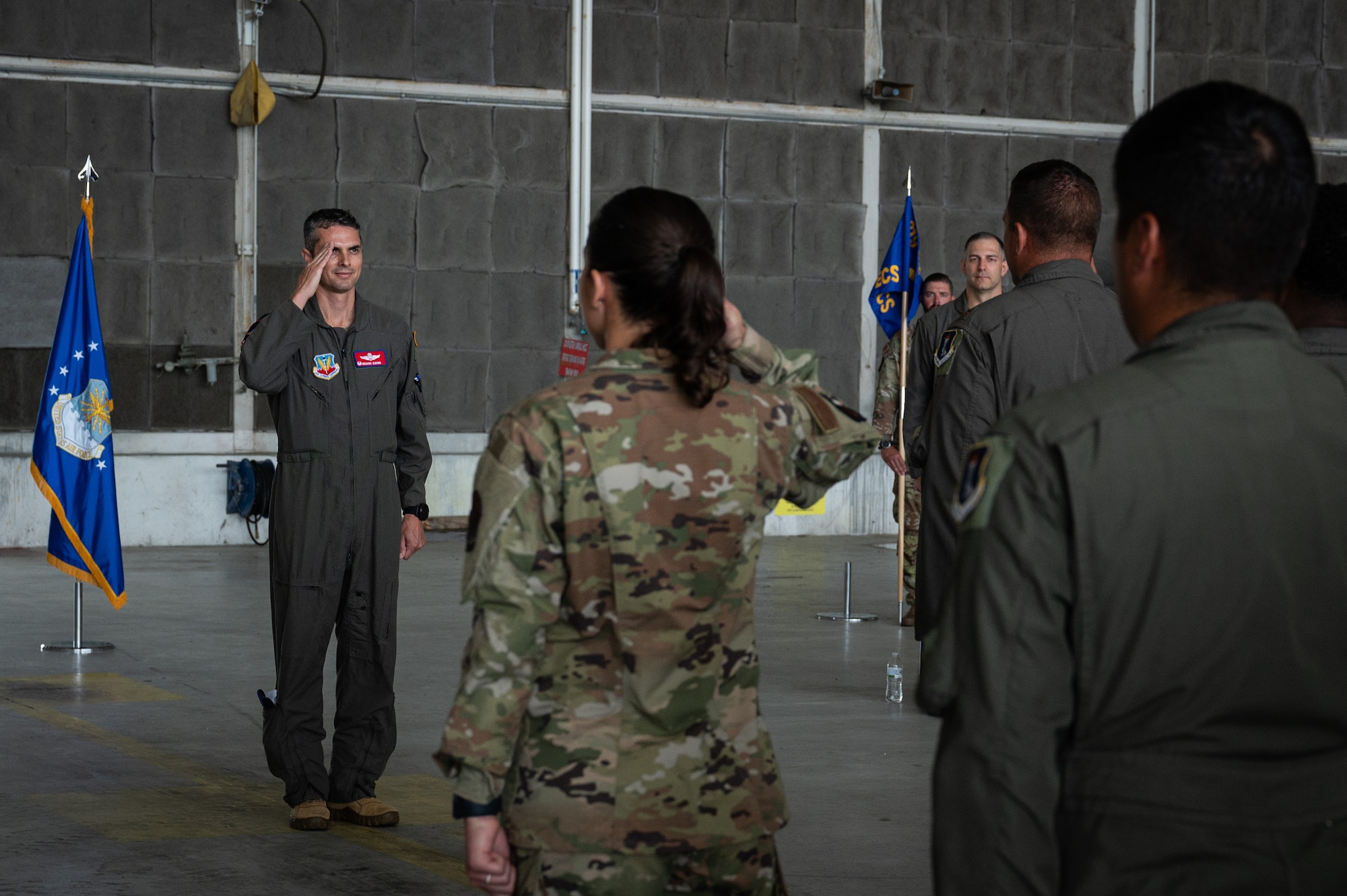 A man gives a salute to a group of airmen.
