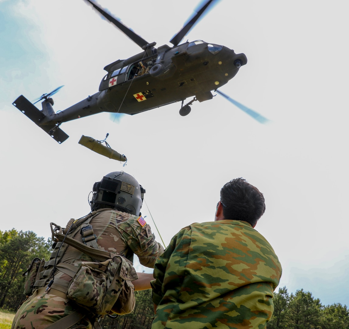 During Exercise Regional Cooperation 25 (RC 25), U.S. Army and Tajikistan partners practice hoisting a training dummy into a UH-60 Black Hawk during a medical evacuation exercise at Camp Edwards, Massachusetts, on June 25, 2025.