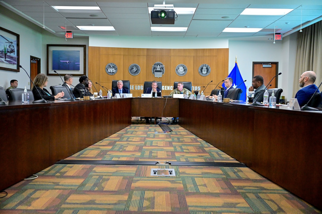 Senior Leaders around table in discussion.