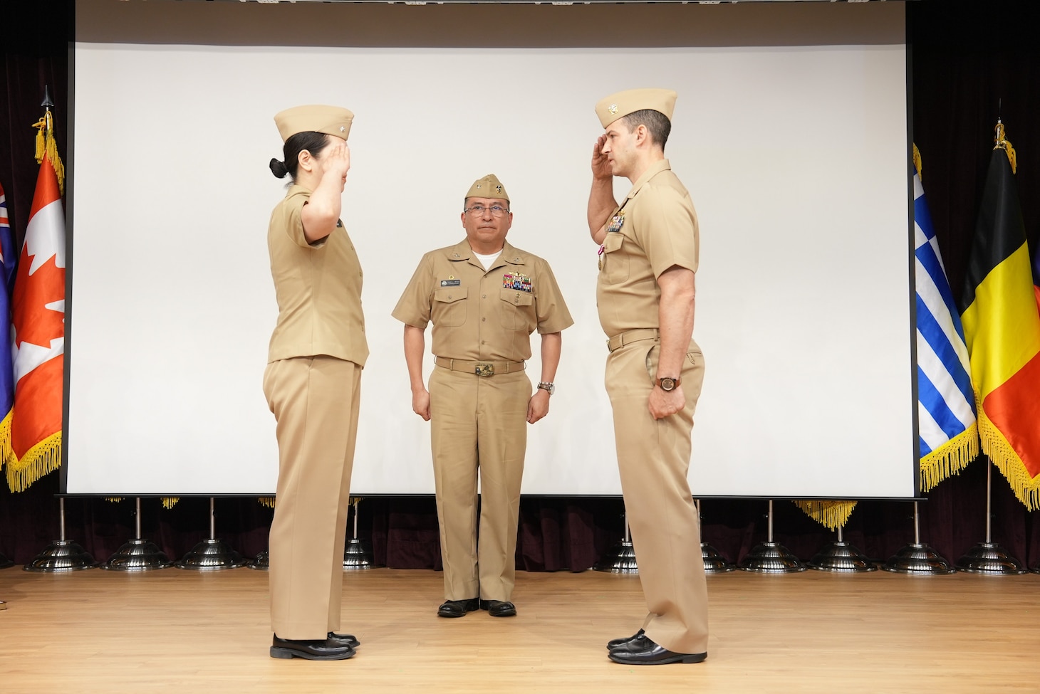 Cmdr. Hannah M. Shipp, left, relieves Cmdr. Patrick J. Moore as commanding officer of Busan, South Korea-based Military Sealift Command Office -Korea, in front of Capt. David L. Reyes, commodore, Military Sealift Command Far East, during a change of command ceremony at the United Nations Peace Memorial Hall in Busan, June 17, 2025.