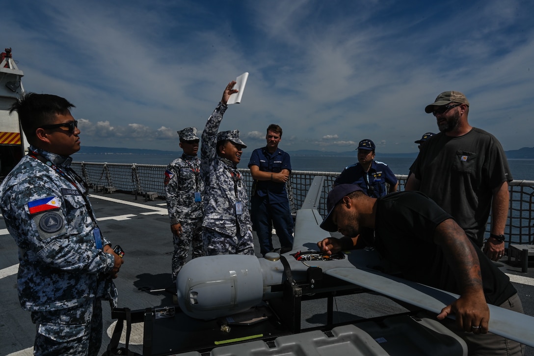 Philippine and Japan Coast Guard members observe a ScanEagle long-endurance unmanned aerial system aboard the Legend-class U.S. Coast Guard Cutter Stratton (WMSL 752) during a trilateral search and rescue exercise in Kagoshima, Japan, June 20, 2025. Stratton is deployed and assigned to Destroyer Squadron (DESRON) 15, the Navy’s largest DESRON and the U.S. 7th Fleet’s principal surface force. Stratton is deployed to the Indo-Pacific to advance relationships with ally and partner nations to build a more secure and prosperous region with unrestricted, lawful access to the maritime commons. (U.S. Coast Guard photo by Petty Officer 2nd Class Kate Kilroy)