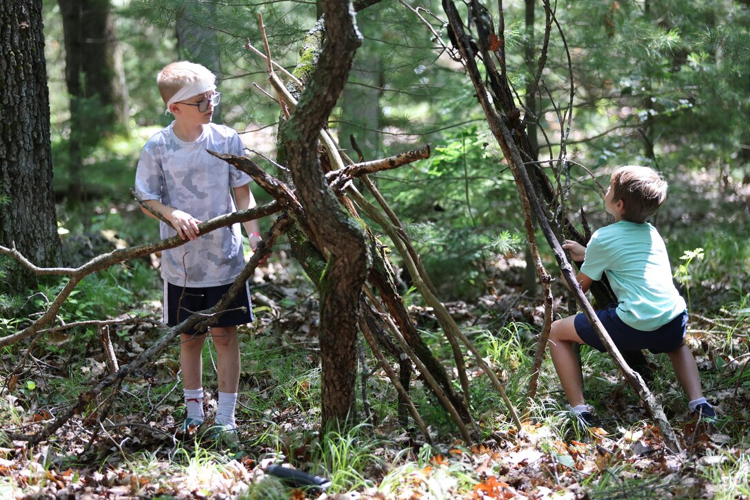 Children of Wisconsin military members build emergency shelters June 20, 2025, as part of a wilderness survival course during the Wisconsin National Guard’s Badger Youth Camp at Camp Lakota near Wautoma, Wisconsin. The annual event, coordinated by the Wisconsin National Guard’s Child and Youth Services office, provided attending military youth a four-day experience designed to foster leadership, teamwork and resilience. (U.S. National Guard photo by Staff Sgt. Olivia Sherman)