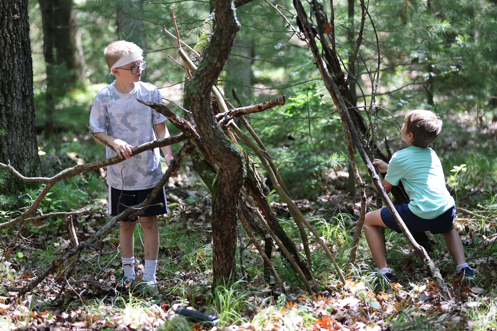 Children of Wisconsin military members build emergency shelters June 20, 2025, as part of a wilderness survival course during the Wisconsin National Guard’s Badger Youth Camp at Camp Lakota near Wautoma, Wisconsin. The annual event, coordinated by the Wisconsin National Guard’s Child and Youth Services office, provided attending military youth a four-day experience designed to foster leadership, teamwork and resilience. (U.S. National Guard photo by Staff Sgt. Olivia Sherman)